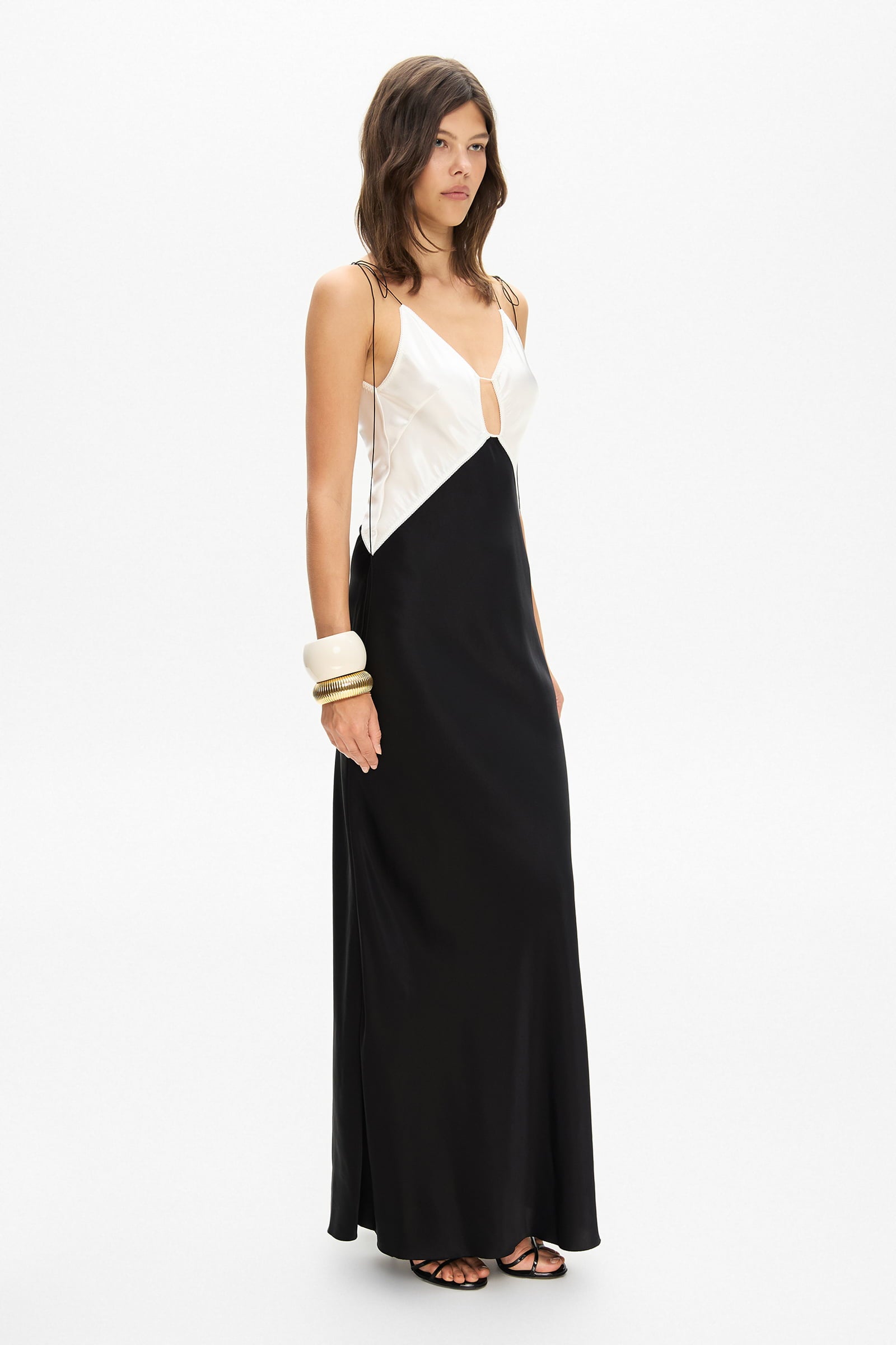 Model in maxi contrast Terrin dress on straps with a cut on the bodice side view