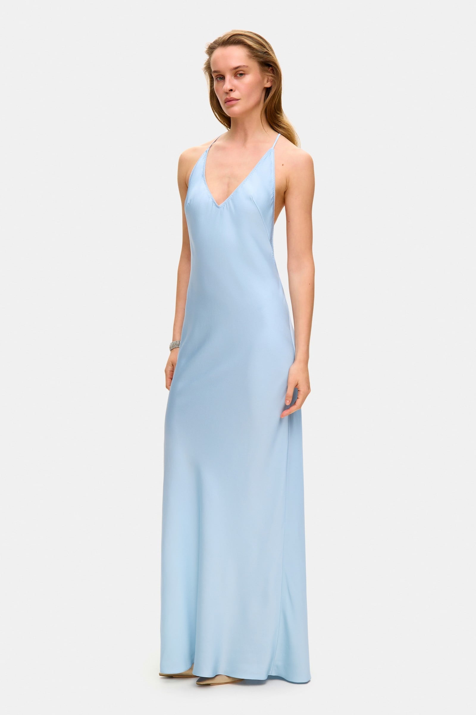 Model in open back Justina maxi dress with open shoulders side view