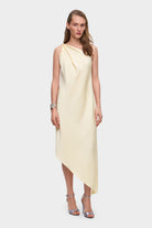 Woman wearing a one-shoulder buttermilk Rina dress on a white background, front view