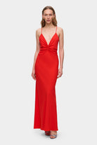Woman wearing a coral Eliana dress on a white background, front view