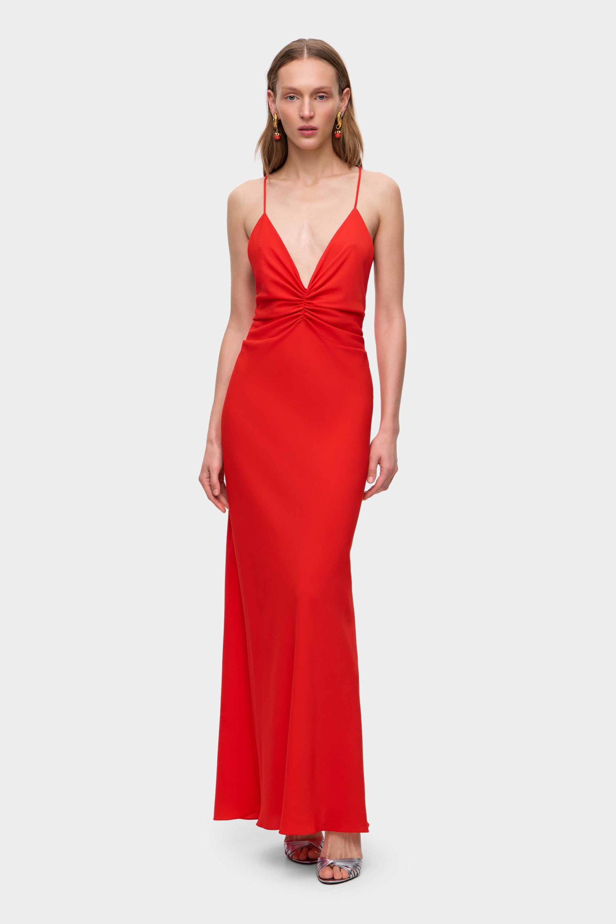 Woman wearing a coral Eliana dress on a white background, front view