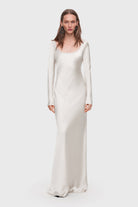 Woman wearing a ivory long-sleeve Margit dress with open back on a white background, front view